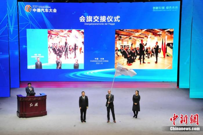 2021年10月19日，2021中德汽車大會(huì)在吉林長春舉行。中外汽車領(lǐng)域的專家學(xué)者、知名汽車廠商及汽車零部件企業(yè)代表和政府官員，圍繞“創(chuàng)新引領(lǐng) 綠色未來”主題展開探討。圖為中德汽車大會(huì)會(huì)旗交接儀式。高龍安 攝
