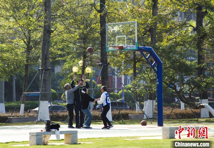 圖為市民、游客在防城港市公園廣場打籃球?！〉岳顝?qiáng) 攝