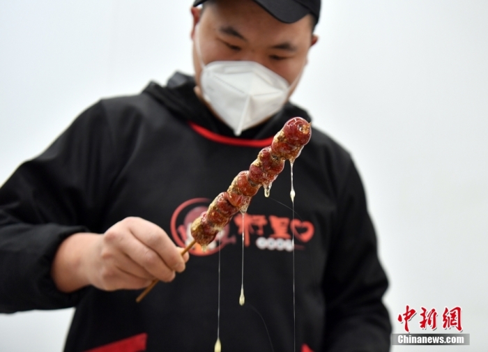 雄安新區(qū)大樹劉莊村辛愛青家中的冰糖葫蘆加工廠，工人正在制作冰糖葫蘆。作為遠(yuǎn)近聞名的“冰糖葫蘆村”，大樹劉莊村制作冰糖葫蘆的歷史已有100多年，全村三分之二的村民都會(huì)這門手藝，吸引不少游客慕名而來(lái)。 中新社記者 韓冰 攝